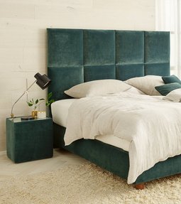 Modernes JOKA Piazza Boxspringbett mit grünem Samt-Kopfteil und hellem Bettzeug in hellgrünem Schlafzimmer