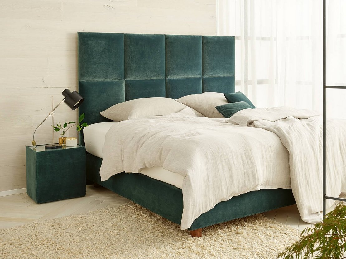Modernes JOKA Piazza Boxspringbett mit grünem Samt-Kopfteil und hellem Bettzeug in hellgrünem Schlafzimmer