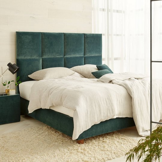 Modernes JOKA Piazza Boxspringbett mit grünem Samt-Kopfteil und hellem Bettzeug in hellgrünem Schlafzimmer