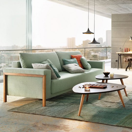 JOKA Time Doppelliege in Mintgrün mit Holzakzenten in geschlossener Sitzposition in einem modernen Loft mit großem Fensterfront-Ausblick.