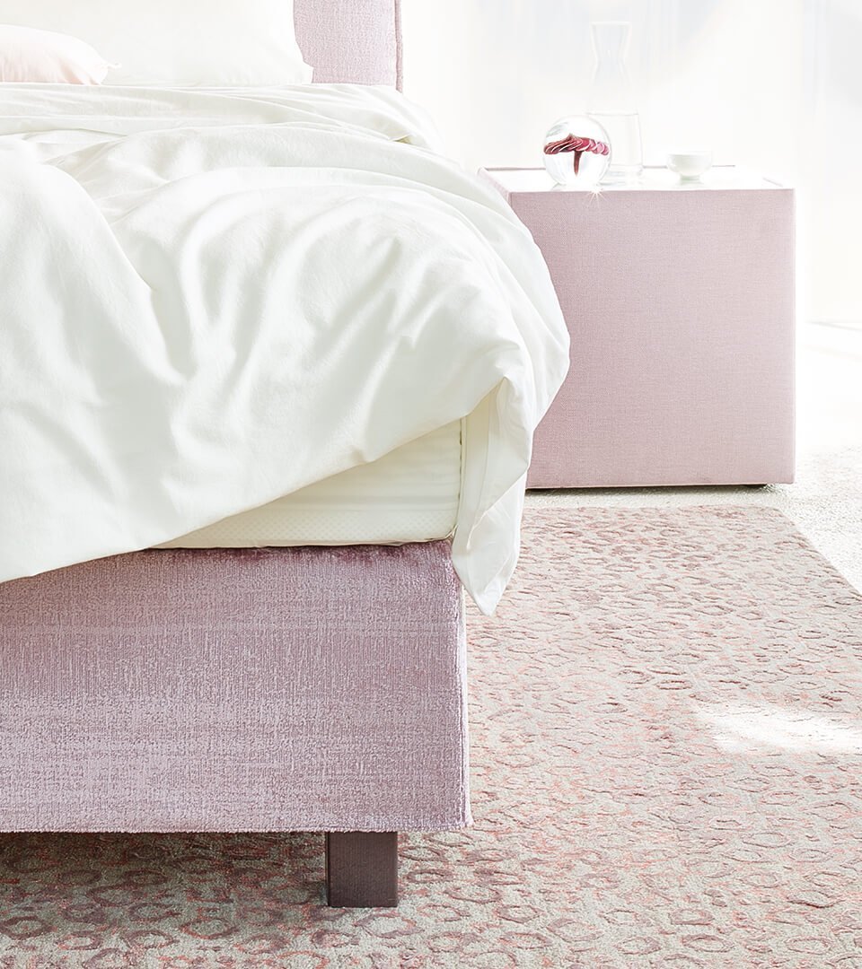 Detailansicht der Fußvariante vom JOKA Capri Boxspringbett in Altrosa mit dunklem Holzfuß
