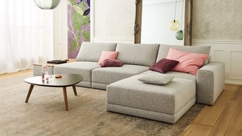 Joka Laguna Ansicht der hellgrauen Eckcouch mit Couchtisch und farbigen Kissen