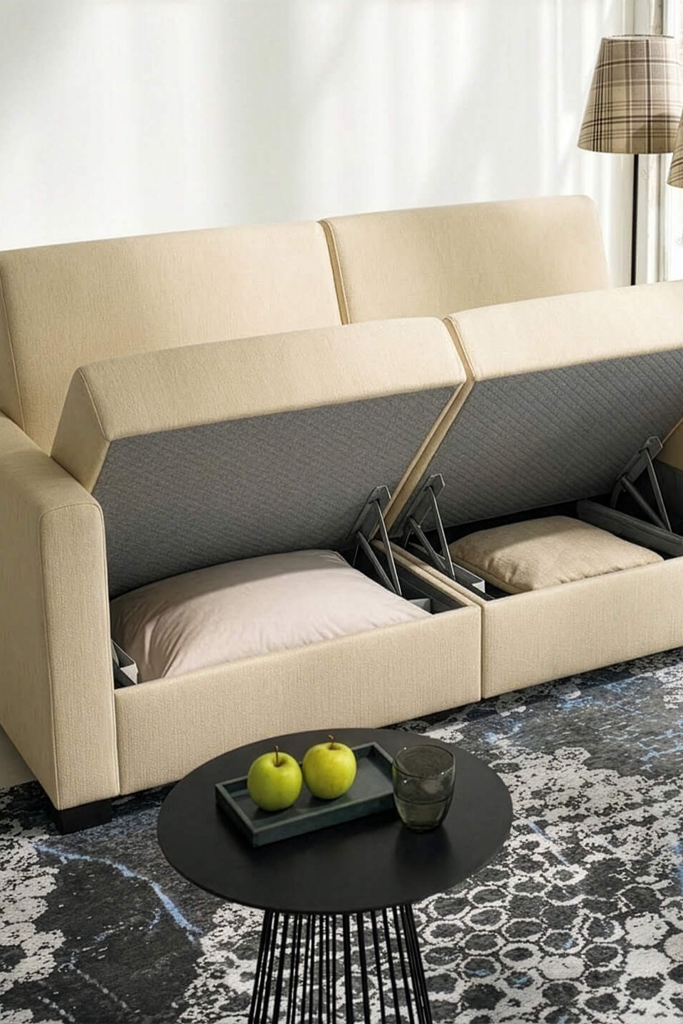 JOKA Magic Längsschläfer mit geöffnetem Stauraum, der den Blick auf integrierte Fächer mit Kissen freigibt, in einem hellen Raum mit Teppich und Beistelltisch.