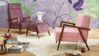 oka Laguna lilafarbener und rosa Fauteuil mit Hocker vor floral gemusterter Tapete