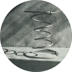 Nahaufnahme einer einzelnen Metallfeder (Bonellfeder) in einer kreisförmigen Vignette.